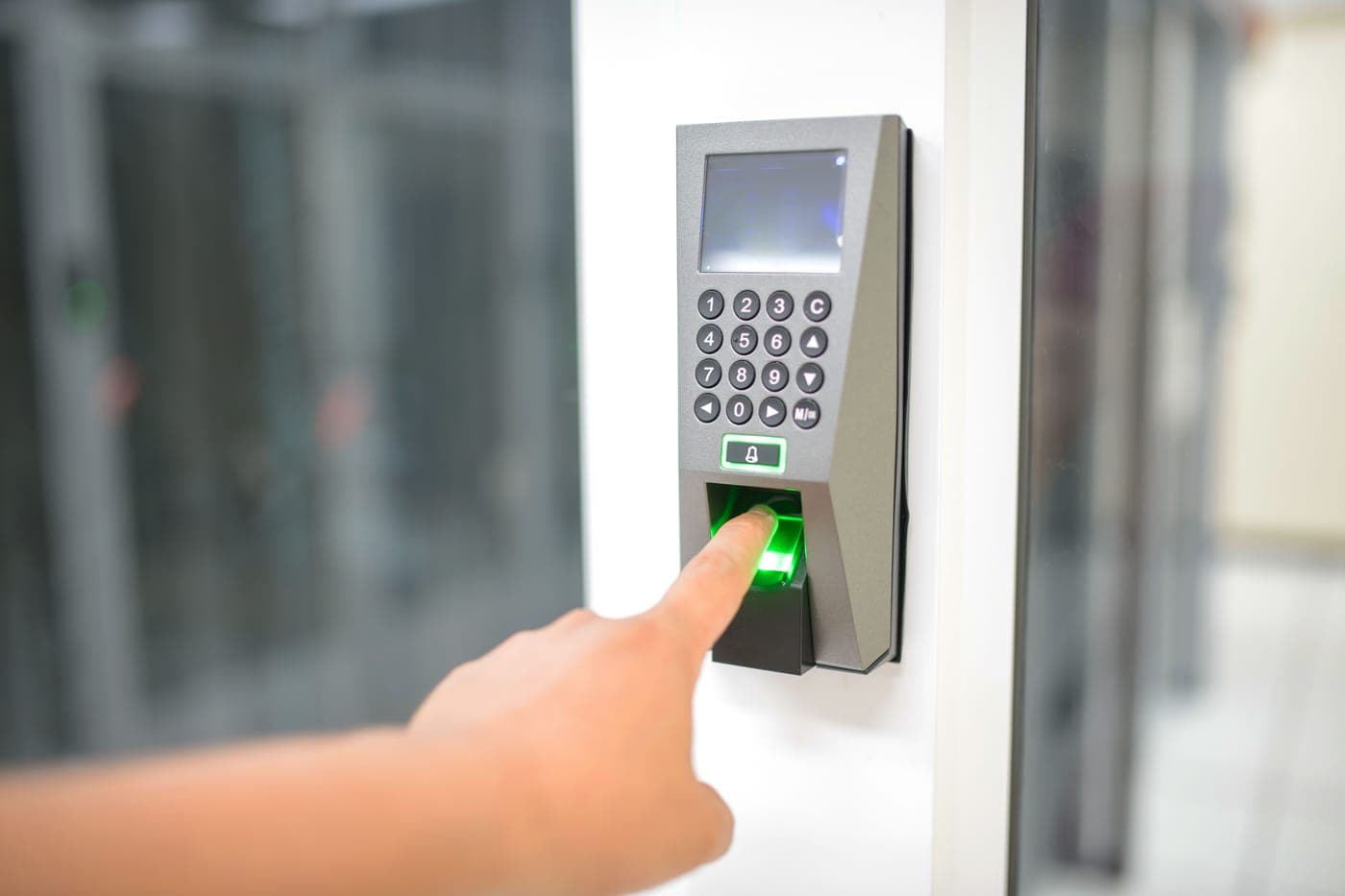 A person pressing a finger to a fingerprint scanner