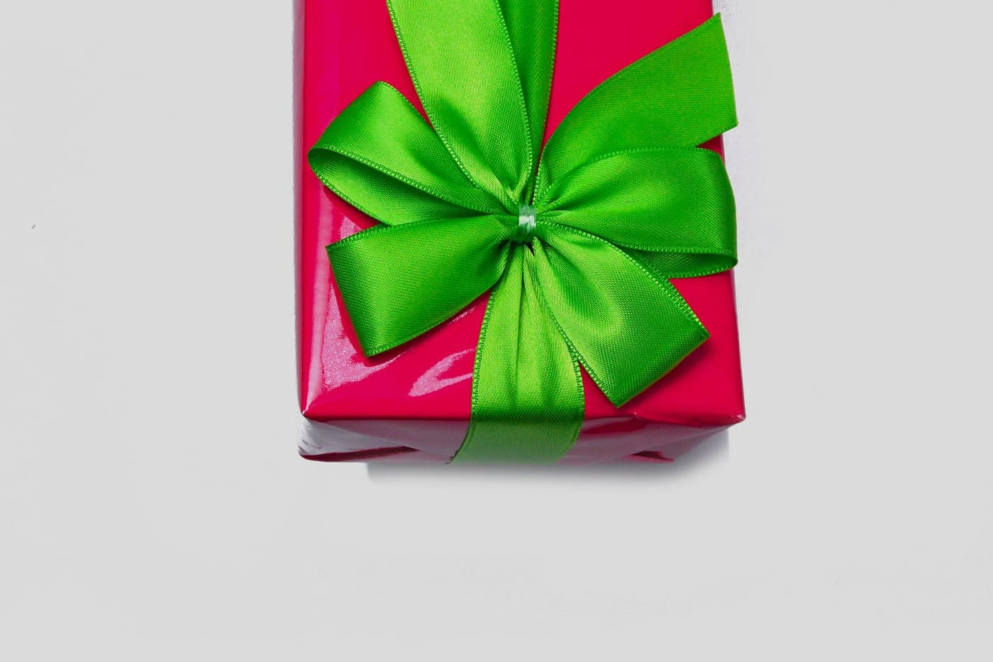 A red wrapped gift tied with a green ribbon bow
