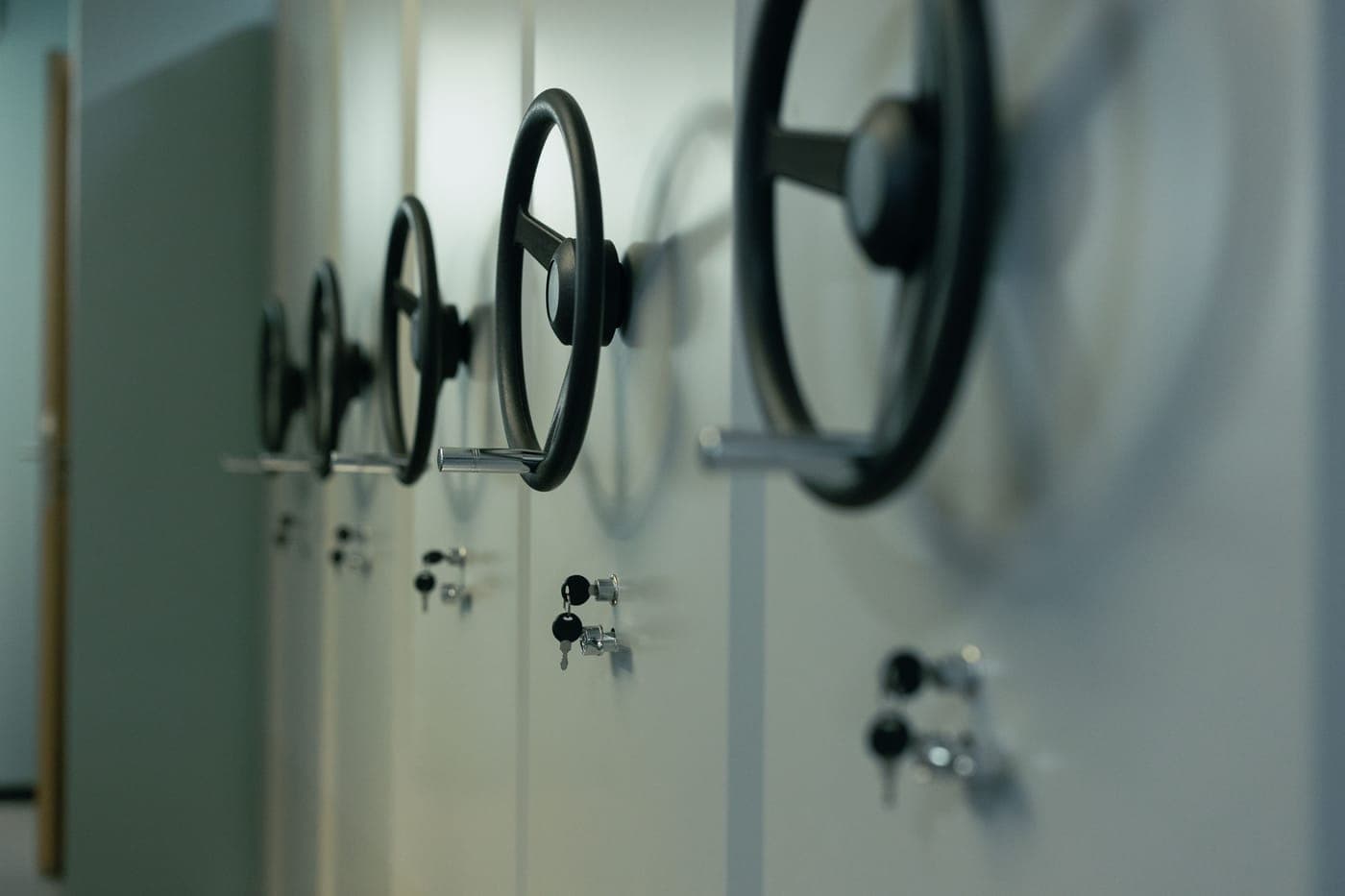 Heavy steel safes with manual locks and keys lined up side by side